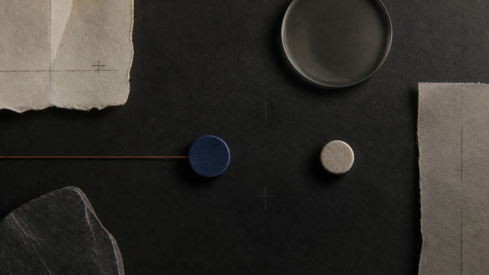 A copper line stopping between a cobalt disc and a pale stone
